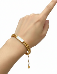 Gold bracelet with a nameplate on a white background