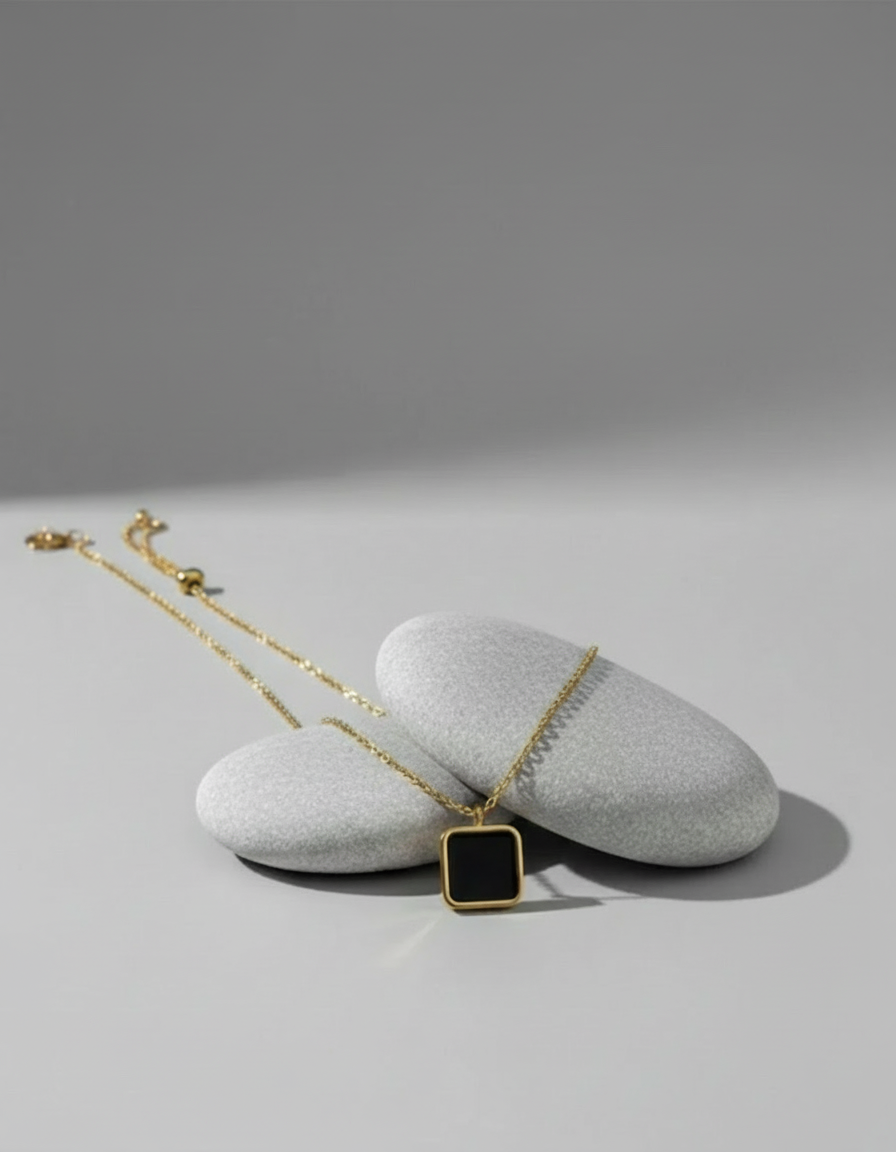 Necklace with a square pendant on a gray surface